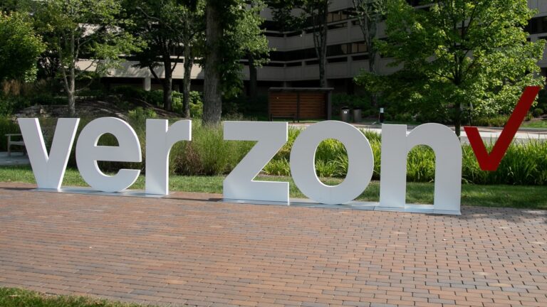 Outside a Verizon corporate building, a sculpture displays Verizon's logo with the letters V-E-R-Z-O-N and a space in the middle where the letter "I" should be.