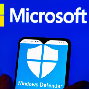 In this photo illustration, the Microsoft Windows Defender logo is seen displayed on a smartphone and Microsoft logo in the background.