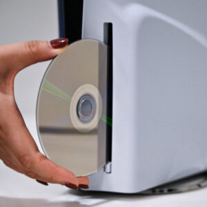 A PlayStation employee demonstrates how to put a disk into the PlayStation 5, at the Sony headquarters building in central Tokyo on November 27, 2024.