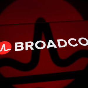 The Broadcom logo is displayed on the screen of a smartphone placed on a reflective surface onto which the company's branding is projected, in Creteil, France, on June 5, 2026.