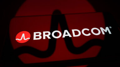 The Broadcom logo is displayed on the screen of a smartphone placed on a reflective surface onto which the company's branding is projected, in Creteil, France, on June 5, 2026.