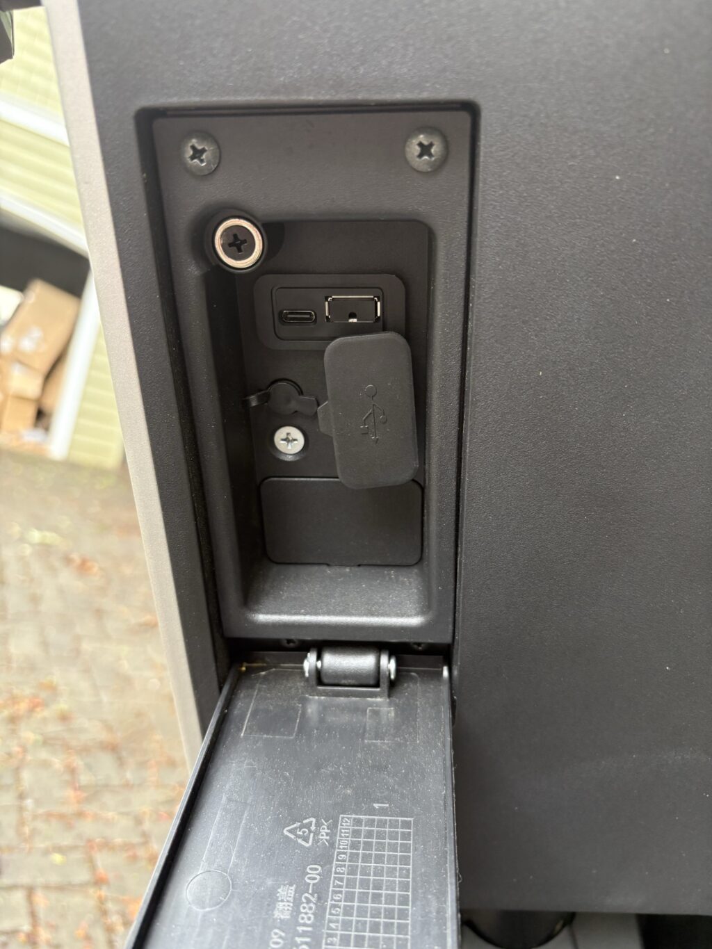 Image of a plastic compartment with the door open, showing USB ports inside.