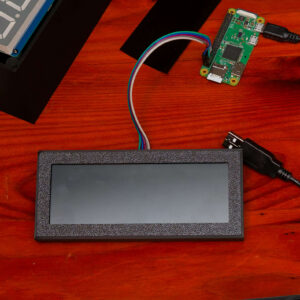Photograph of a workspace with 3d printed clock components and some electronics