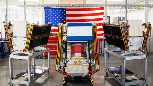 Three of the first operational satellites in the FireSat constellation sitting on carts in a building owned by California-based Muon Space.