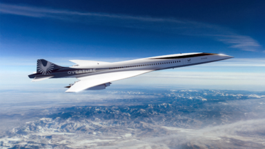 A concept illustration of an Overture supersonic airliner flying over the Rocky Mountains.