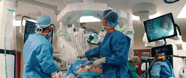 A surgeon and surgical team prepare to operate on a patient using a Da Vinci 5 surgical robot.