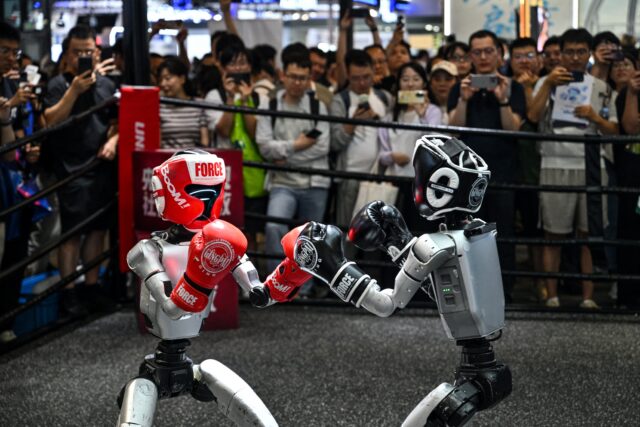 Humanoid robots controlled by a remote control by Unitree Robotics take part in a fight during the World Artificial Inte