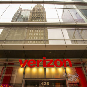 The front of the Verizon store in Times Square in New York City on July 16, 2026. The Verizon logo is visible above the door, with the reflections of skyscrapers seen in the building's upper facade.