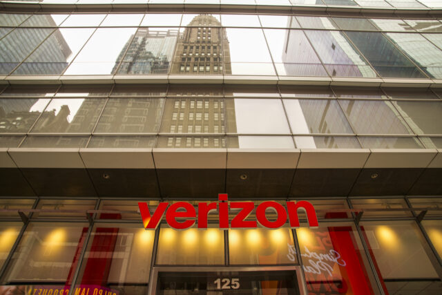The front of the Verizon store in Times Square in New York City on July 16, 2026. The Verizon logo is visible above the door, with the reflections of skyscrapers seen in the building's upper facade.