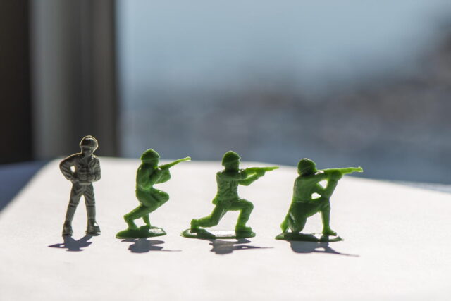 Toy soldiers preparing an ambush. Miniature toy soldiers on a table.