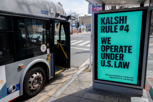 A Kalshi advertisement at a bus stop displays the text, "We operate under US law because Kalshi is a federally regu