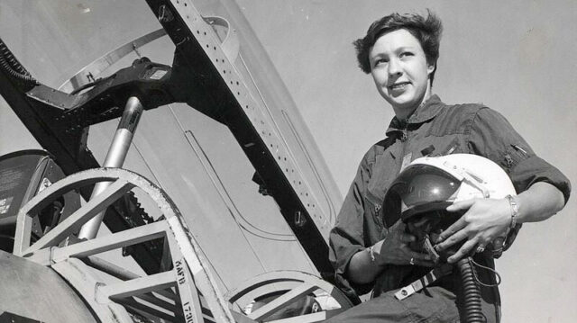 black and white image of a young women pilot on a ladder leading into a jet