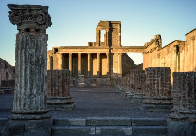 The sun rises over colonnade ruins at Pompeii