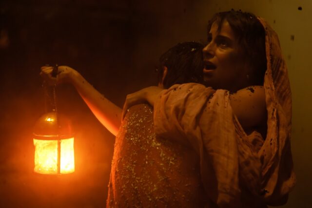 Avianius, played by Frankie Treadaway, and his mother Claudia, played by Madeleine Walker, embrace in the dark, ash-clogged street of Pompeii.