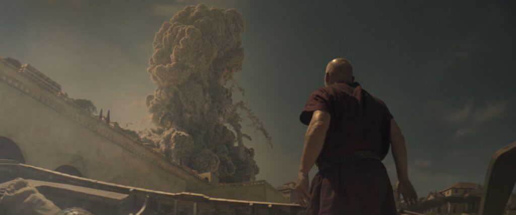 The Praetorian, played by Barry Aird, stands on the beach looking up in horror as the eruption column from Vesuvius towers into the sky over the city walls of Herculaneum.