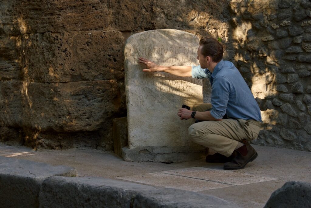 Tom Hiddleston kiểm tra một dòng chữ tại tàn tích Gatehouse ở Pompeii