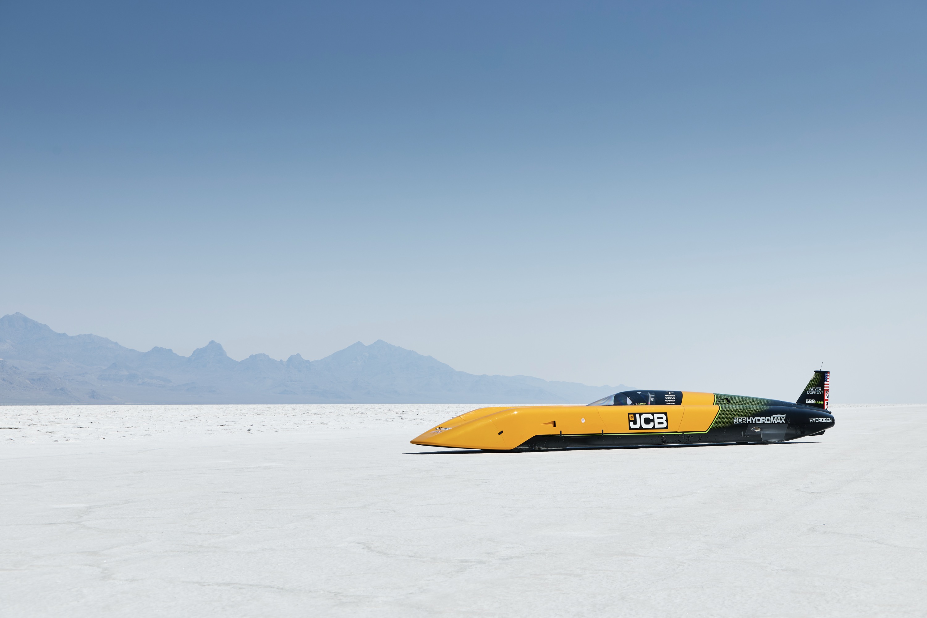 A yellow land speed record car on a salt flat