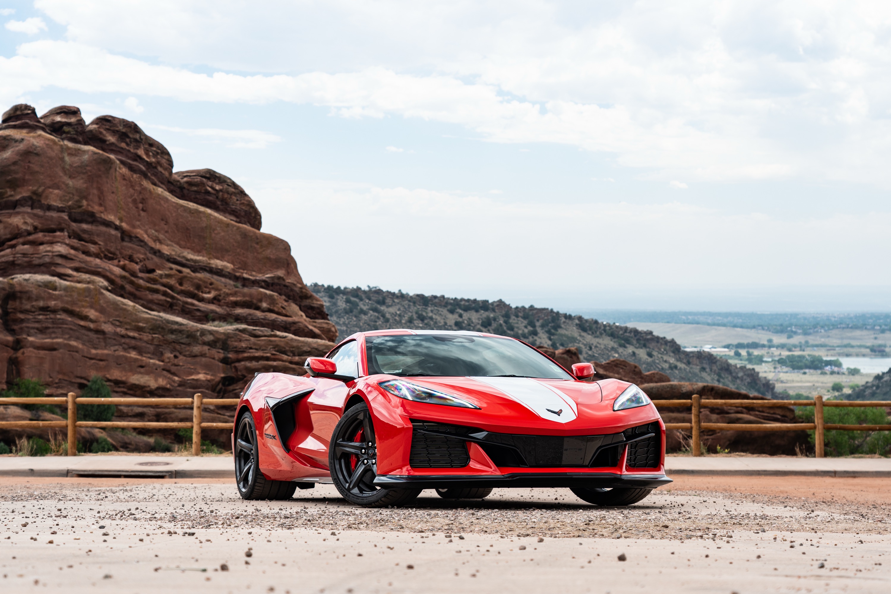 A red Corvette parked by a red rock formation