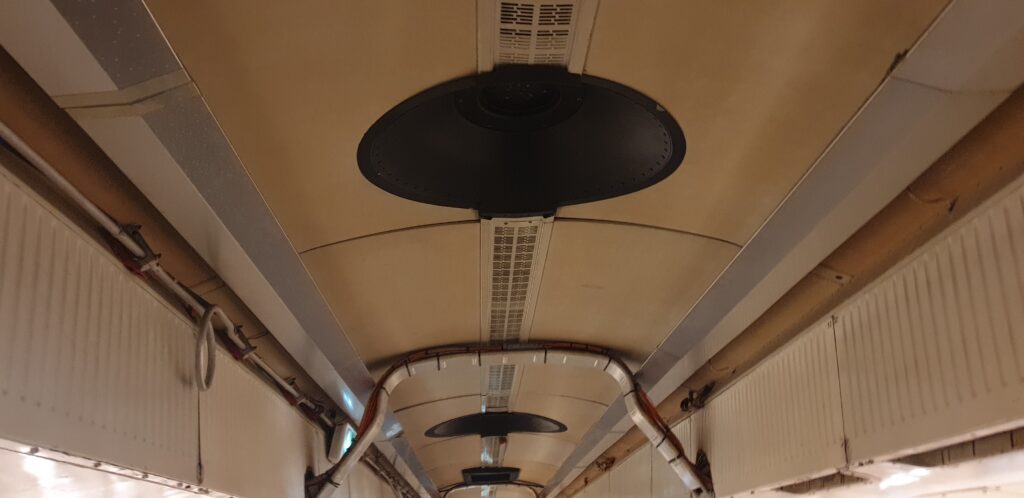 Image of the ceiling of an aircraft with black inserts in it.
