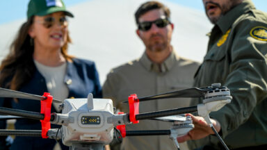 US Agriculture Secretary Brooke Rollins watches a Customs and Border Protection officer talk about a quadcopter drone sitting in the foreground. The CBP drones have been retasked to help USDA survey animals for signs of screwworm infestation.