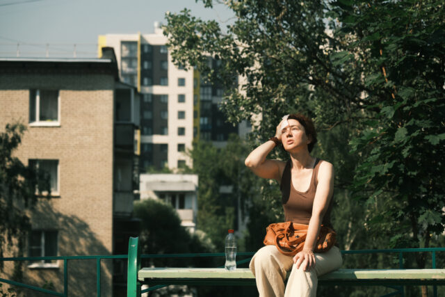 Woman is feeling bad during the heat wave in city