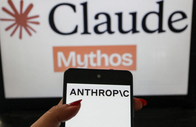 A smartphone displaying the Anthropic logo is shown in the foreground with a blurred Claude Mythos themed background. The image illustrates the branding of the artificial intelligence company in a technology themed visual composition.