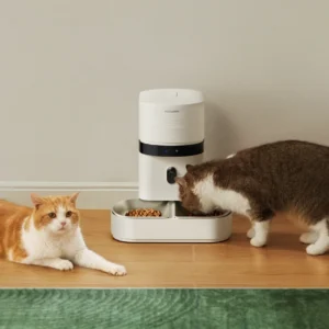 A cat sitting next to a Granary 2 that another cat is eating out of.