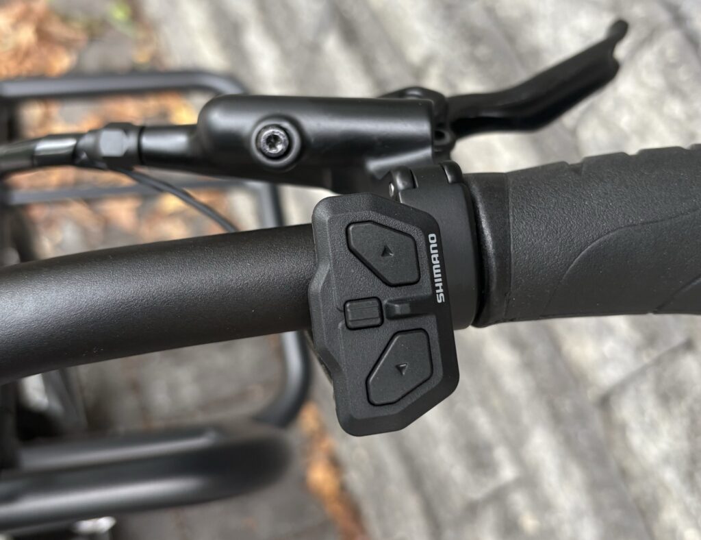 Image of part of a handlebar with a controller that contains just a few buttons.