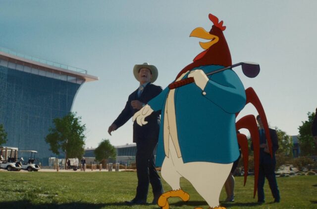 man in cowboy hat walking and talking with a large cartoon rooster