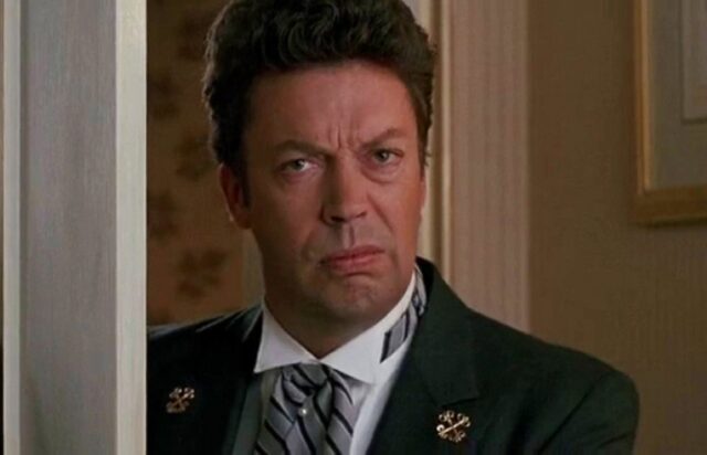 doorman in uniform with a sneering expression on his face
