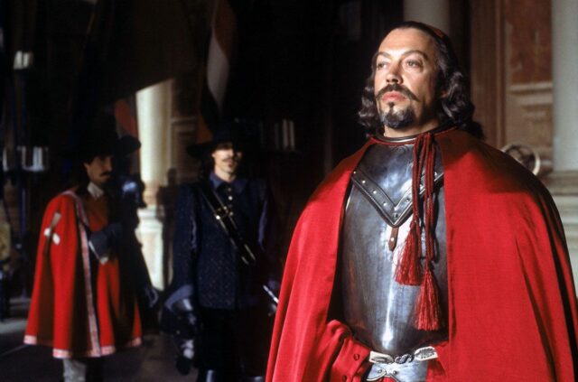 bearded man in 17th century cardinal's robes looking pompously severe