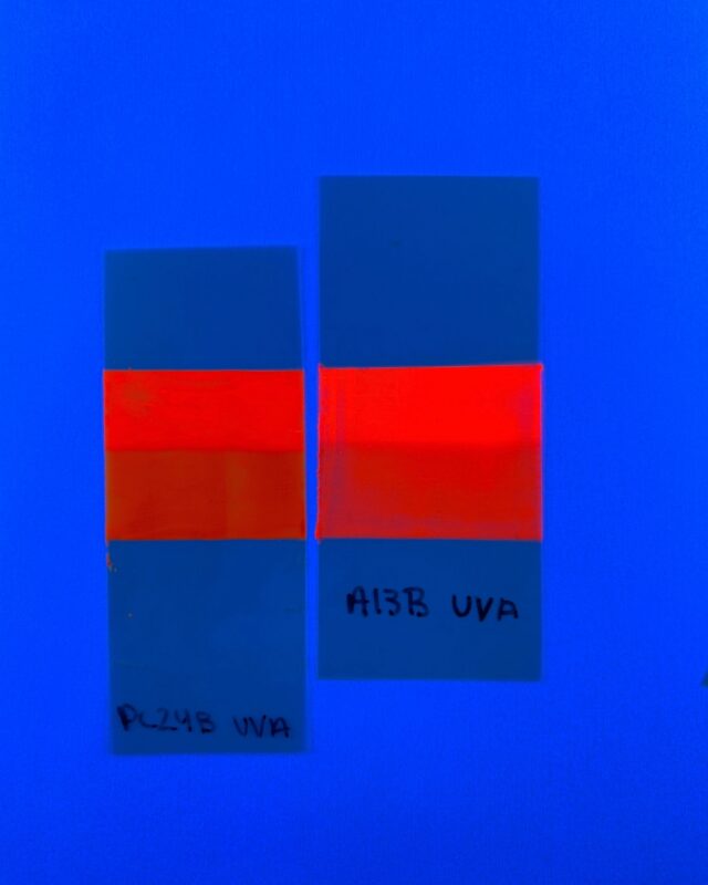 The darkening on the bottom half of these fluorescent tape strips shows that the optical brightener in the tape degraded faster than the pigmentary color when exposed to light. The top half of the strips was shielded from light exposure.