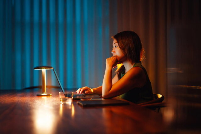 A woman using a laptop at night