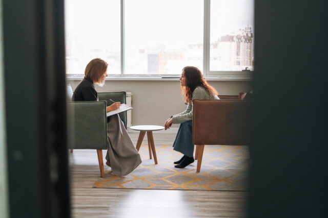 Young woman talking to psychologist in the office