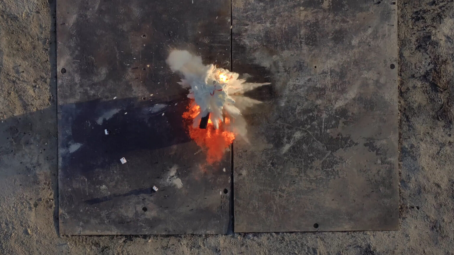 Fire retardant balls dropped by Anduril's Ghost-X drone explode on a fire in a test. The scene from above shows a cloud of fire retardant just spreading out wit