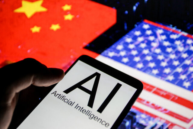 Close up view of a smartphone displaying the words AI Artificial Intelligence in front of blurred flags of the United States and China illustrating technological competition between the two countries.