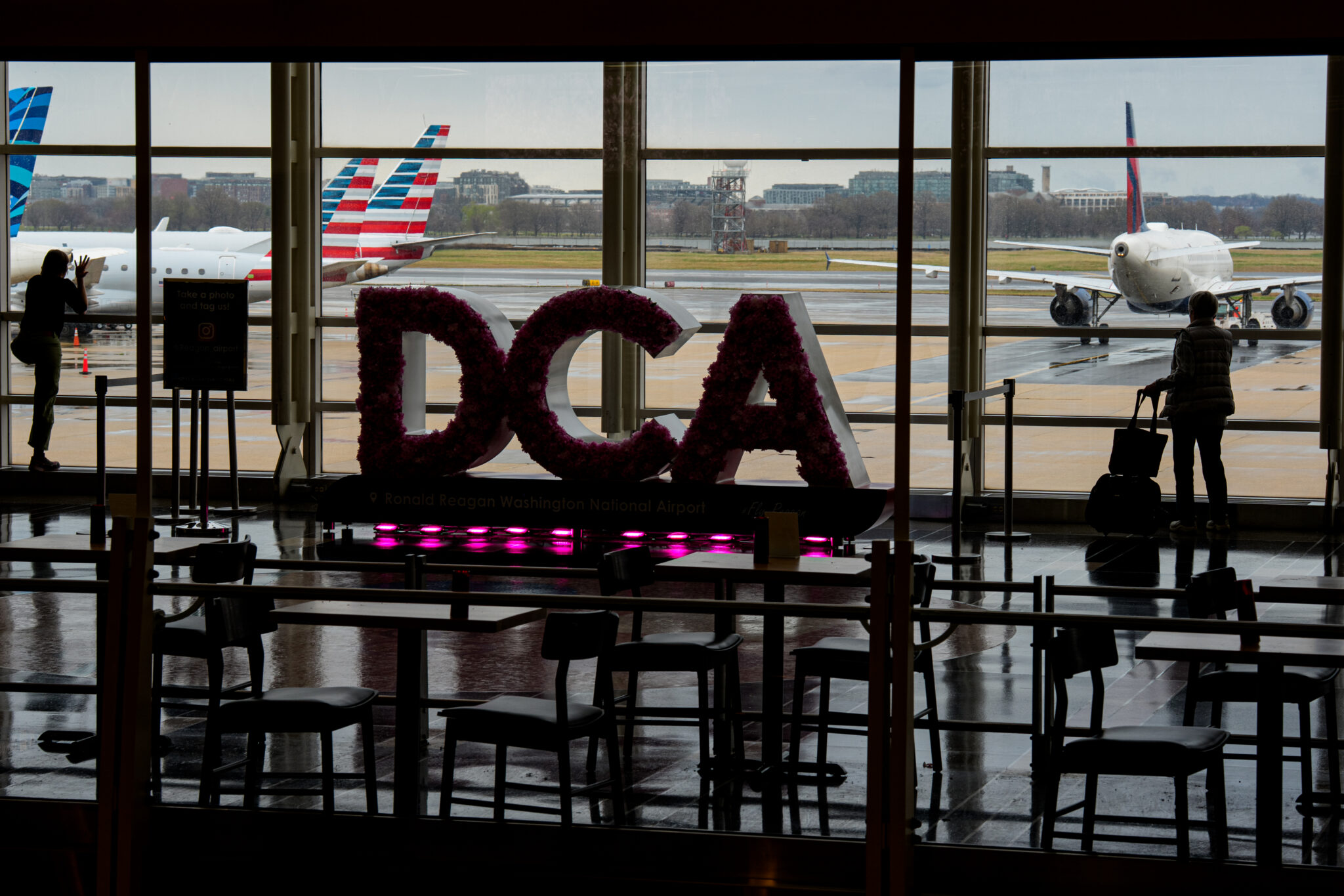 Passengers stand in one of the terminals at Ronald Reagan Washington National Airport on March 16, 2026 in Arlington, Virginia. The airport name's shorthand DCA
