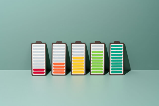Paper Craft of a row of Rechargeable Batteries Gradually Charging to Full on a Green Background .