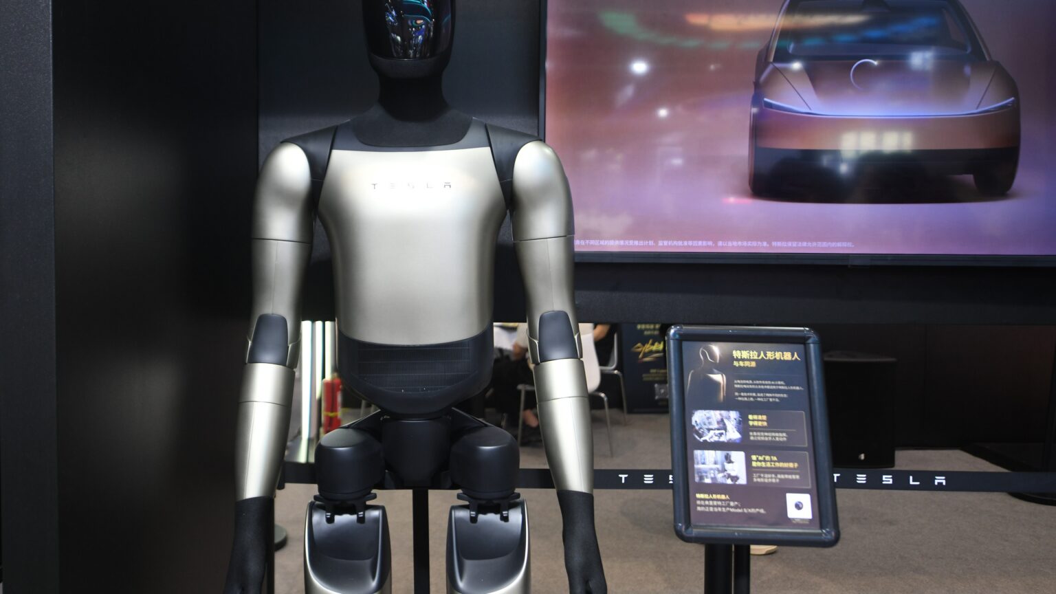 Tesla's Optimus Gen-3 humanoid robot at an exhibition in Hangzhou, Zhejiang Province, China on September 23, 2026. The robot is standing in front of a screen di