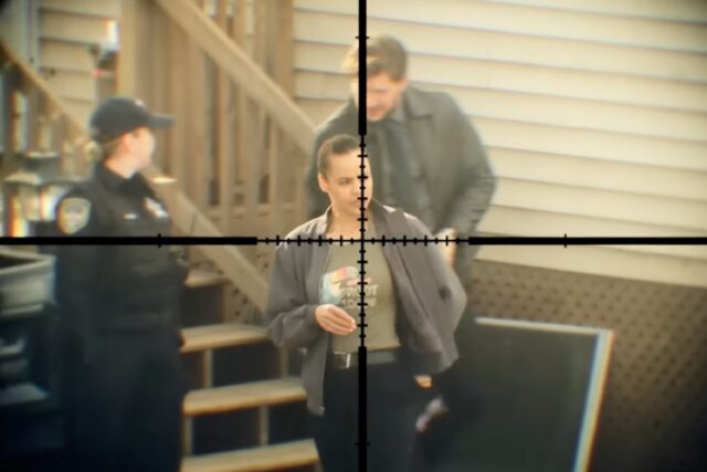 shot of black woman in jeans and tee shirt in the crosshairs of a rifle scope