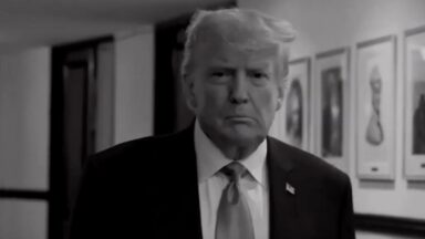 Trump walking down a hallway in a screenshot from a TV commercial.