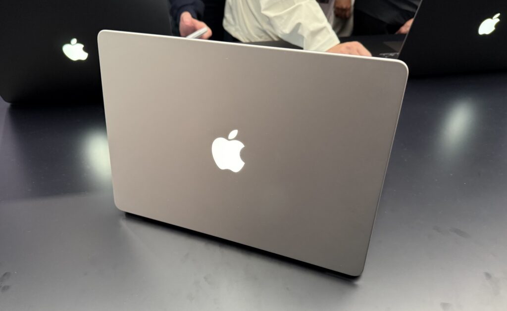 The logo glowing on the back of an open 14-inch MacBook Pro.