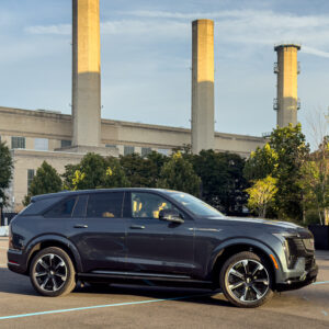 A Cadillac Escalade IQ parked near a power station