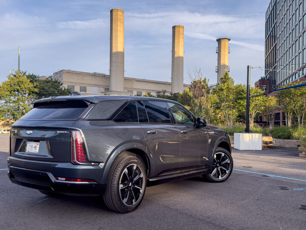 A Cadillac Escalade IQ parked near a power station