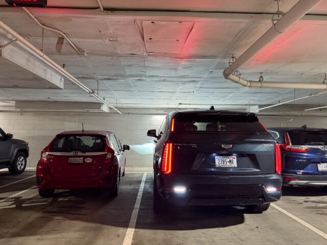 Cadillac Escalade IQ parked in an underground lot next to some small cars
