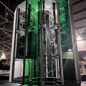 A vertical photo showing the size of the Cray-1 replica project. A large C-shaped tower stands lit up with green accent lighting.