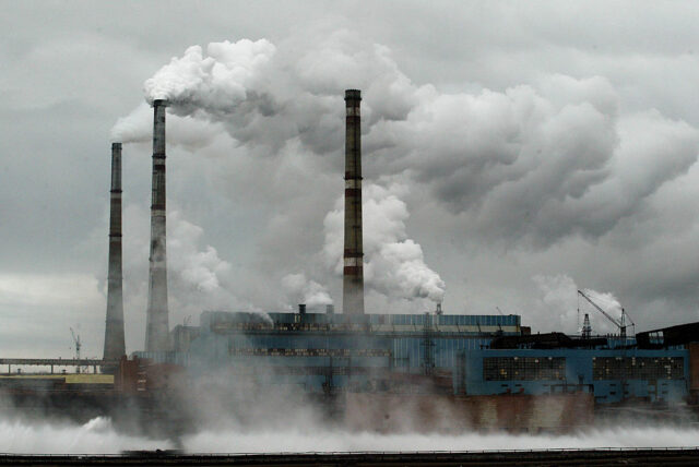 Image of a facility with large smokestacks in a snowy environment.