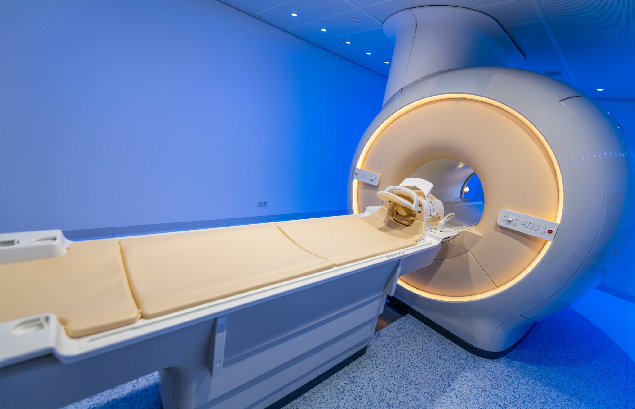 Image of an MRI tube in a room with blue lighting.