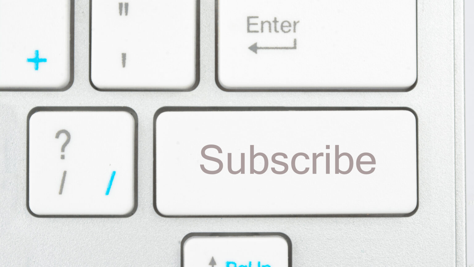 A picture of a white keyboard zoomed in on a key that says "Subscibe."
