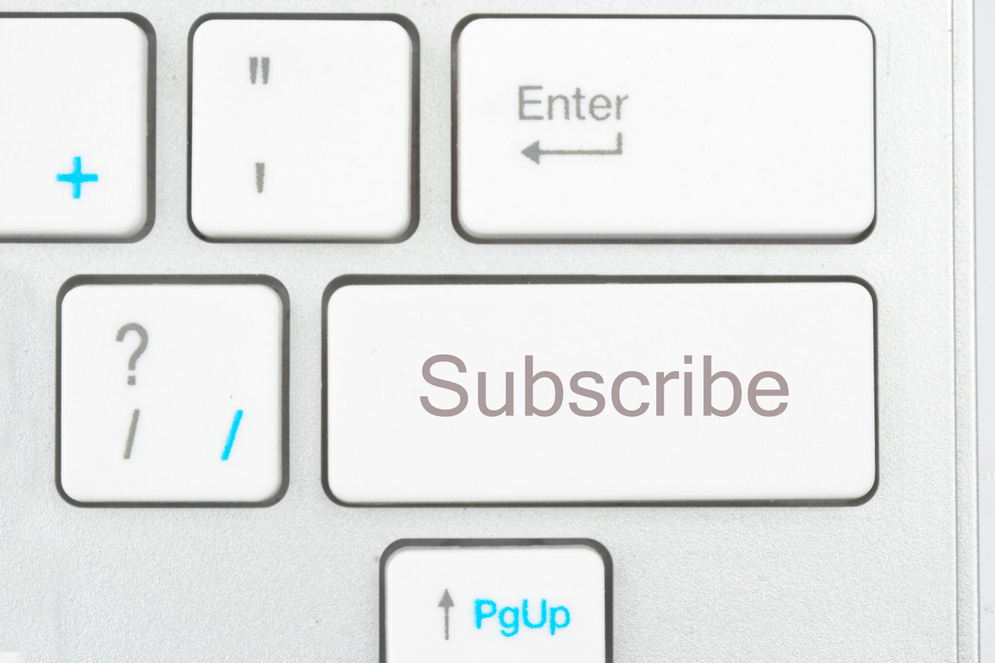 A picture of a white keyboard zoomed in on a key that says "Subscibe."